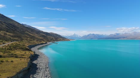 Establishing-drone-shot-Mount-Cook-in-front-of-Lake-Pukaki-during-sunny-day-in-New-Zealand