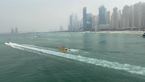 Puerto-Deportivo-De-Dubai-Vista-Panorámica-De-Gran-ángulo-De-La-Residencia-De-La-Playa-De-Jumeirah-Con-Barcos-Cruzando-El-Mar-Durante-El-Día