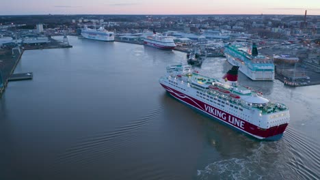 Aerial-view-of-Viking-Line-cruise-ship-Amorella-manoeuvring-in-the-harbor-basin-in-preparation-to-come-alongside-during-lowlight-morning-sunrise