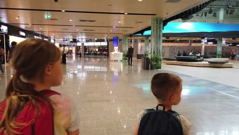 Helsinki,-Finland---July-2019-:-Children-with-backpacks-walking-in-the-hall-of-the-Helsinki-airport