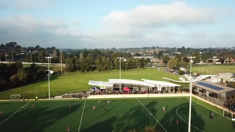 Rise-up-and-pan-down-drone-footage-over-men's-premier-league-field-hockey-match-at-Elgar-Park