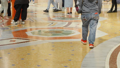 People-walking-over-mosaic-floor,-Galleria-Vittorio-Emanuele-II,-Milan