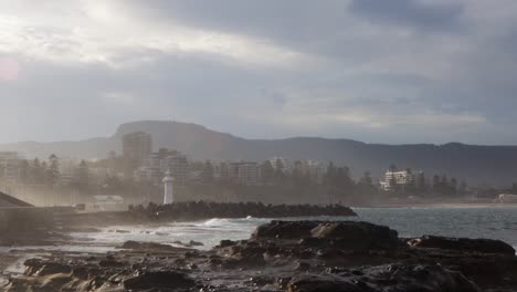 El-Agua-Choca-Contra-La-Costa-Rocosa-Del-Faro-Y-De-La-Ciudad-De-Wollongong,-Nueva-Gales-Del-Sur.