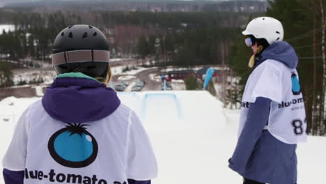 Chicas-Practicando-Snowboard-Riéndose-De-Una-Montaña-De-Esquí-En-Suecia