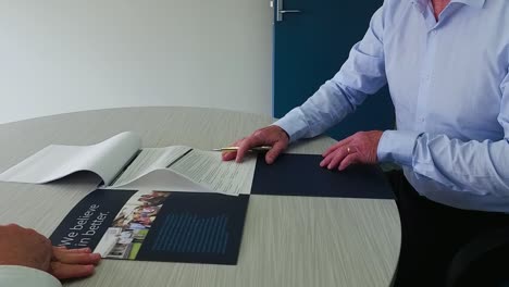 People-signing-documents-at-desk