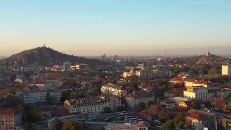 Reveal-of-Plovdiv-city-in-Bulgaria-with-hills-in-the-background-and-blue-skies