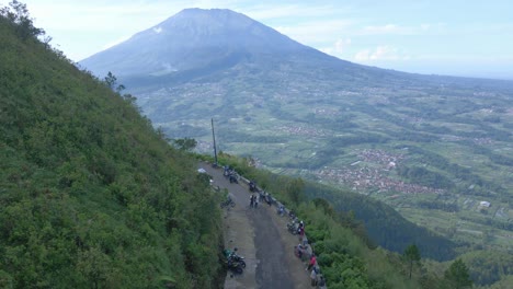 Aerial-view-of-road-on-the-slope-of-Mount-Telomoyo-with-view-of-Merbabu-Mountain-on-the-background