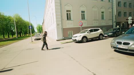 Older-man-crossing-street-in-sunny-Eastern-European-city-dynamic-steadicam