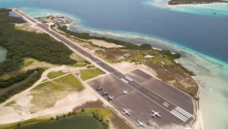 Aerial-shot-of-Los-Roques'-airstrip-with-parked-planes-and-turquoise-sea