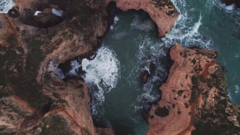 Geradeaus-Absteigender-Blick-Auf-Erodierte-Felsformationen-Von-Küstenklippen-Und-Tosende-Wellen-Durch-Eine-4K-Drohne-An-Der-Ponta-Da-Piedade-In-Der-Nähe-Von-Lagos-In-Der-Algarve-In-Portugal