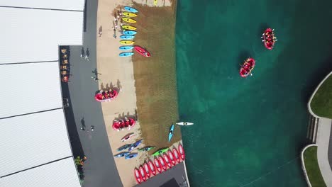 Aerial-drone-bird-view-shot,-of-a-bunch-of-people-playing-water-sports,-water-rafting,-kayaking,-in-a-water-park