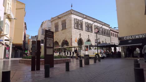 Perpignan-is-busy-with-tourists-on-a-public-holiday-in-llate-Spring-with-the-crowded-tourist-train-running-through-the-main-square