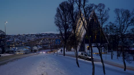 Cars-Passing-By-Tromso-Arctic-Cathedral-At-bright-snowy-Night