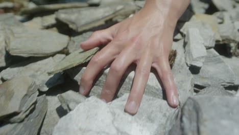 Running-hand-across-and-through-slate-rock-in-slowmotion