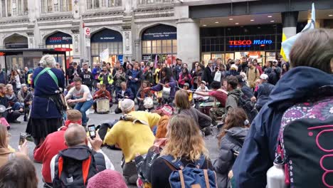 Extinction-Rebellion-Demonstranten-Tanzen,-Um-Das-Bewusstsein-Vor-Der-Tesco-U-Bahn-In-Der-Liverpool-Street-Station-Zu-Schärfen