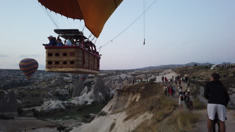 Un-Globo-Aerostático-Sobrevuela-A-La-Gente-En-El-Mirador-De-Goreme-Durante-El-Amanecer.