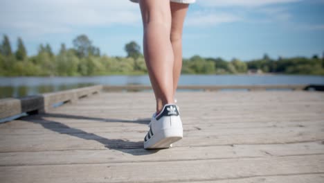 Walking-across-a-wooden-dock-on-a-lake-in-the-summer