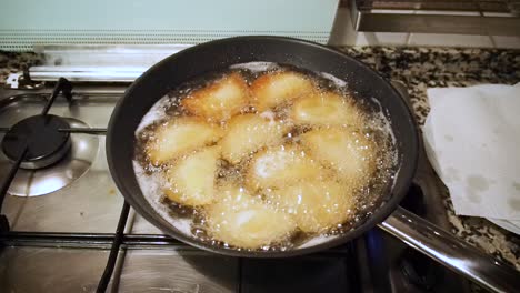 View-footage-of-Rissoles-fried-into-a-pan-full-of-hot-oil-in-her-kitchen