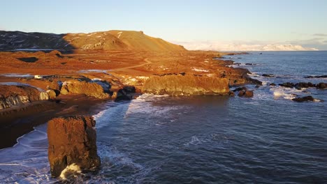 Aerial-Dolly-Shot-Along-the-Icelandic-Coastline-with-Warm-Sunlight-Over-the-Beautiful-Scenic-Landscape