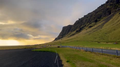 Paisaje-Escandinavo-De-Carretera-De-Montaña-Por-Puesta-De-Sol-Nublada-En-Islandia,-Plano-Amplio