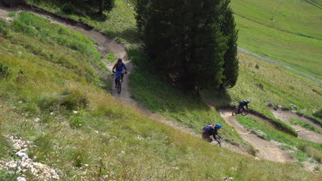 Three-mountain-bikers-ride-down-a-mountain-bike-trail-in-a-bike-park