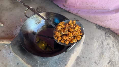 A-man-preparing-Pakora-being-fried-in-hot-oil-in-local-Dhaba-in-Bihari-Style-in-earthen-traditional-stove-in-India