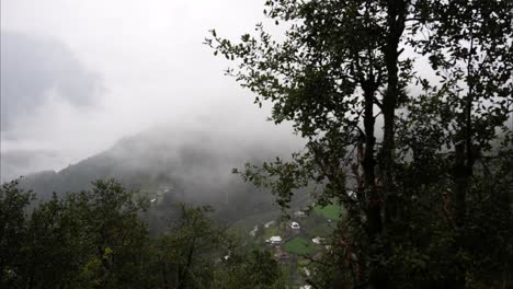 Timelapse-view-of-fog-enveloping-a-mountain-village-after-rain-in-the-Lower-Himalayan-region-of-Kashmir