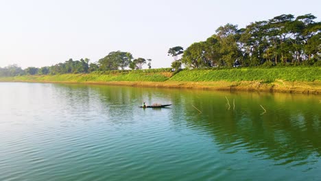 Pescador-Pescando-En-Un-Barco-En-El-Río-Surma,-Bangladesh---Disparo-Aéreo-De-Un-Drone