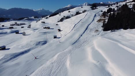 Pista-De-Esquí-Tranquila-En-Un-Día-Soleado-En-Un-Valle-Alpino-Con-Nieve-Blanca,-Antena