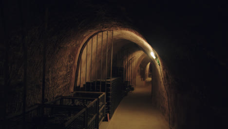 General-shot-of-a-dimly-lit-underground-wine-cellar-in-Burgos,-Spain-with-los-light