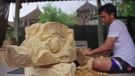 Barong-Bangkal-Maske-Mit-Einem-Balinesischen-Holzschnitzer-Bei-Der-Arbeit-Im-Hintergrund