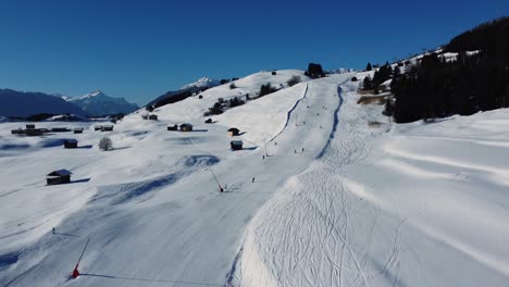 Beginner-piste-with-skiers-going-downhill-in-Austria-on-sunny-day