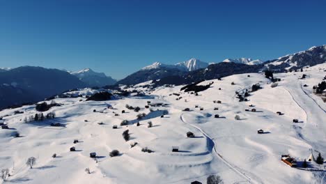 Ländliche-Berglandschaft-Im-Winter-Mit-Schnee-Und-Holzhütten