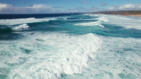 Luftaufnahmen-Eines-Paares-Mit-Einer-Drohne-In-4K-Auflösung,-Das-Den-Panoramablick-Auf-Den-Malerischen-Strand-Mit-Perfekten-Wellen-Zum-Surfen-Am-Sandstrand-Von-Bordeira-In-Der-Algarve-Region-Von-Portugal-Genießt