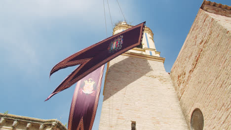 Gegenschuss-Eines-Mittelalterlichen-Tempels-In-Huelva,-Spanien-Mit-Einer-Flagge-An-Einem-Sommermorgen