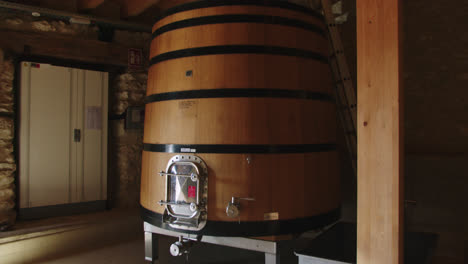 Slow-motion-shot-of-a-large-wooden-barrel-containing-wine-at-temperature-in-a-factory-in-Burgos,-Spain