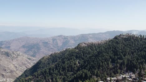 Panoramic-aerial-view-showing-dense-forests-and-scattered-villages-near-a-national-park-in-Khyber-Pakhtunkhwa,-Pakistan
