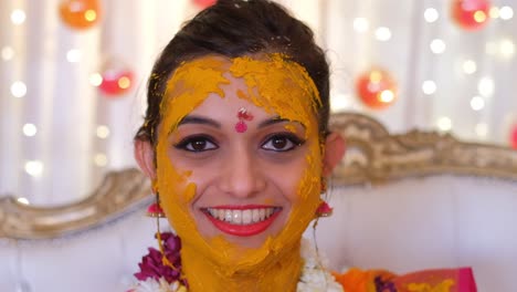 Indische-Braut-Mit-Kurkuma-Im-Gesicht-Während-Der-Haldi-Zeremonie---Nahaufnahme