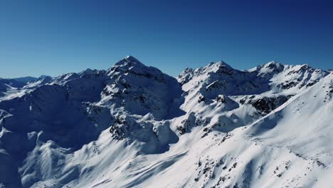 Beautiful-sunny-day-in-Alps-with-snow-covered-mountains,-aerial