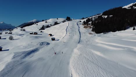 Perfect-downhill-ski-slope-on-sunny-day-in-Austria,-aerial