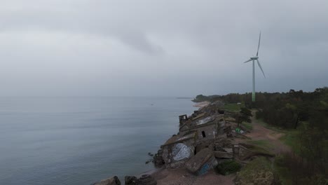 Establishing-Aerial-View-of-Abandoned-Seaside-Fortification-Building-at-Karosta-Northern-Forts-on-the-Beach-of-Baltic-Sea-,-Overcast-Day,-Wide-Drone-Shot