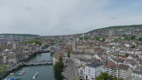 High,-orbiting-drone-shot-showing-the-skyline-of-Zurich-city,-the-skyline,-bridges,-river-and-cathedral