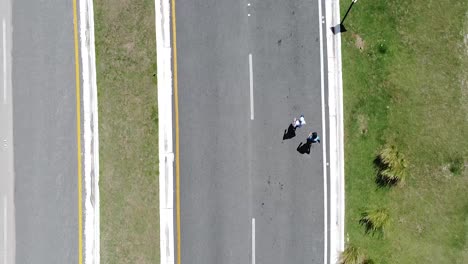 Luftaufnahme-Einer-Drohne-Mit-Fokus-Auf-Die-Straße,-Während-Menschen-Rennen