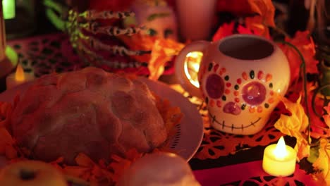 Sugar-skull-and-pan-de-muerto-offering-on-Day-of-the-Dead-altar,-close-up