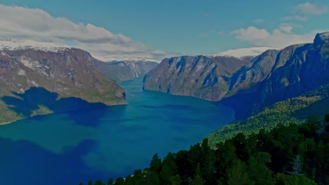 Drone-shot-looking-out-over-Norway's-beautiful-water-surrounded-by-steep-mountains