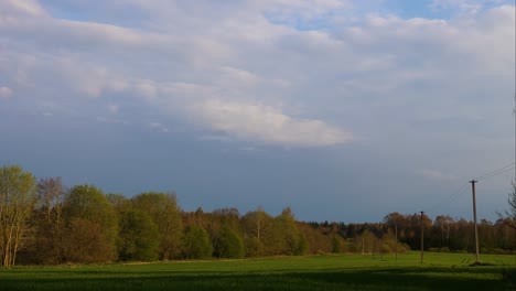 Timelapse-De-Nubes-De-Tormenta-Acercándose-Por-Encima-Del-Campo-Agrícola-Verde,-Letonia
