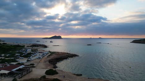 Playa-De-Cala-Comte-Con-Barcos,-Impresionante-Cielo-Al-Atardecer-En-Ibiza