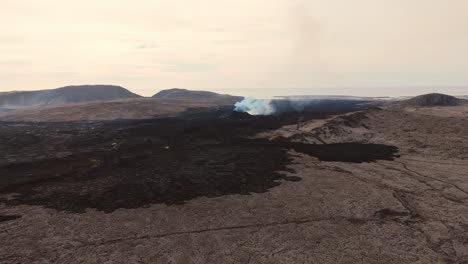 Desolate-volcanic-wasteland-with-smoking-volcano-and-igneous-rocks