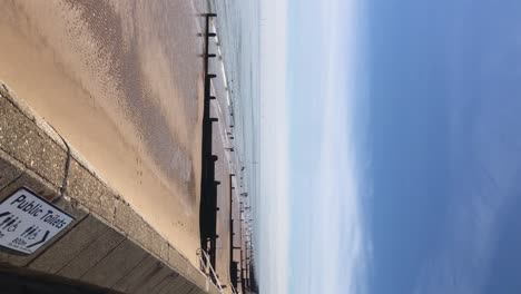 Vídeo-Panorámico-Vertical-Que-Muestra-Cabañas-De-Playa-Y-El-Mar-En-Frinton-On-Sea-En-Essex,-Reino-Unido