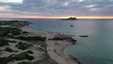 Playa-De-Cala-Comte-Con-Barcos,-Impresionante-Cielo-Al-Atardecer-En-Ibiza